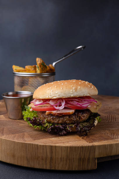 istock Delicious hamburger with cutlet, greens, sauce and tomatoes 1614203235