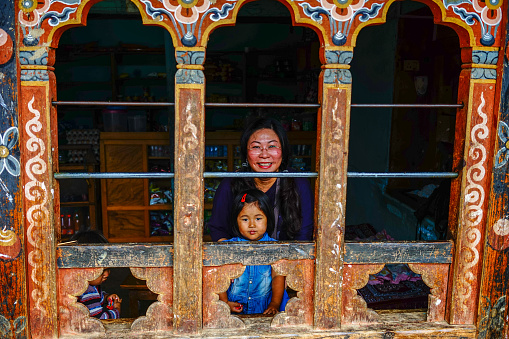 Thimphu, Bhutan - Aug 30, 2015. A Tibetan woman with her child at a traditional house in Thimphu, Bhutan. Bhutan is a small country in the Himalayas between Tibet and India.