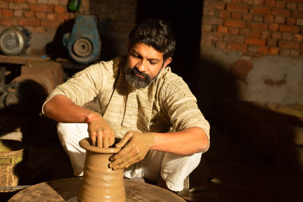 istock Indian male pottery maker building a clay pot, Beard man worker or labour working.skill india concept. 1614214400