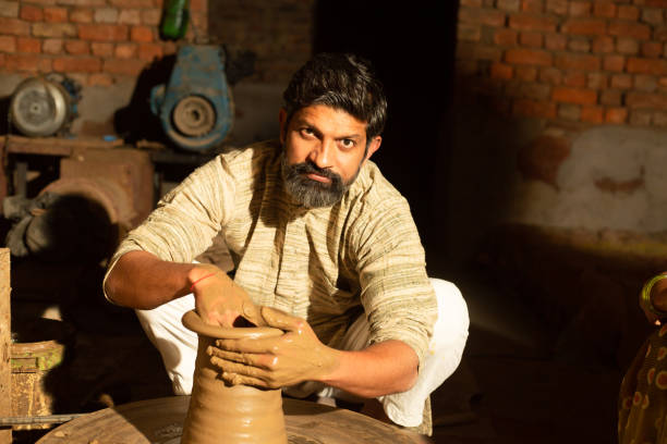 istock Indian male pottery maker building a clay pot, Beard man worker or labour working.skill india concept. 1614214932