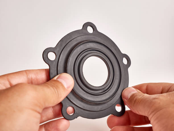 A man holds a black rubber gasket for a heating boiler in his hands.