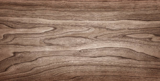 istock Walnut tree texture close up. Wide walnut wood texture background. Walnut veneer is used in luxury finishes. 1614240738