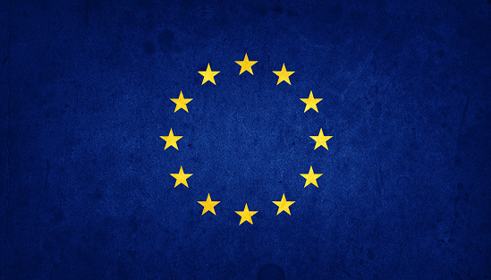 European Union EU flag on the grunge old wall. Closeup of grunge European Union flag on vintage background.