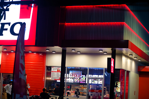 KFC restaurant in Bangkok at night. Scene is at KFC at Wanghin Road in Bangkok Ladprao. Inside are customers and people