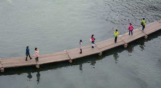 Hunan, China - Nov 6, 2015. People on wooden bridge at Fenghuang Ancient Town in Hunan, China. Fenghuang is a well-preserved town located in western Hunan Province.
