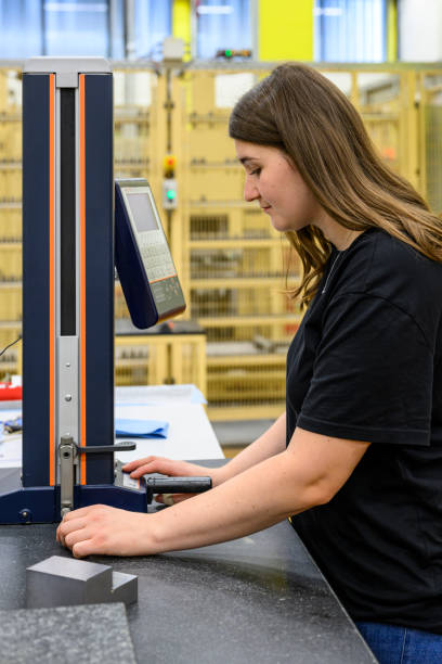 istock Concentrated young woman working at a measuring machine in a workshop 1614348100