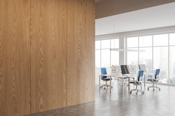 istock Cozy coworking interior with pc monitors, armchairs and window. Mockup wall 1614354869