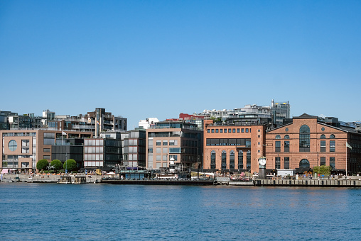 Summery impressions of Norway's Capital Oslo: Partial View of a Central District from the Harbor with Restaurants, Cafés and a Ferry