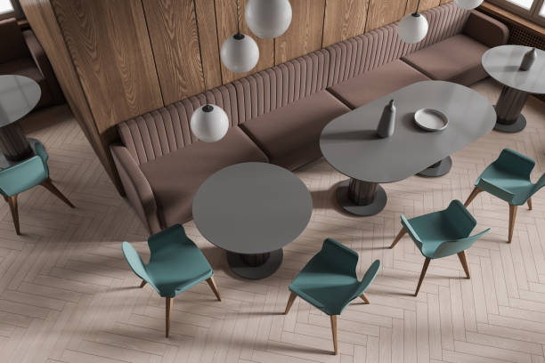istock Dark wooden cafe interior with round tables and sofas, top view 1614358588