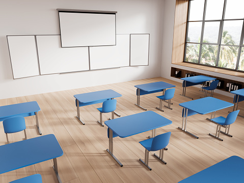 Corner of modern classroom with white walls, wooden floor, rows of blue tables and chairs and mock up projection screen and whiteboard. 3d rendering