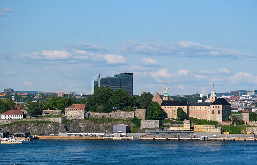 Impressive view from the Oslo Fjord of the Norwegian capital Oslo, showcasing many famous landmarks and buildings, along with the skyline and numerous boats on the water, blue sky, copy space