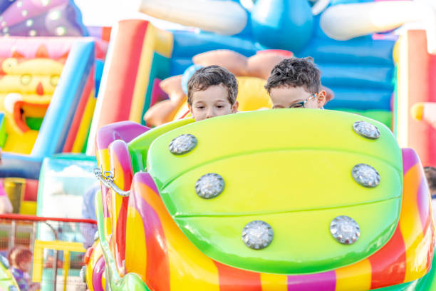 istock Two kids driving a carousel at the amusement park. 1614369043