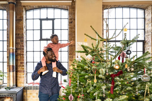 istock British father and toddler daughter looking at holiday tree 1614369295