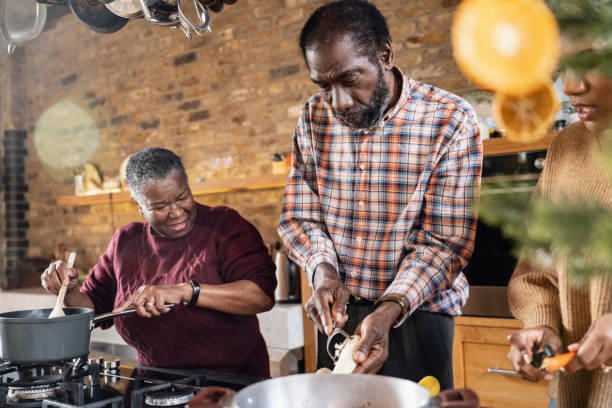 Black family members peeling and cooking root vegetables