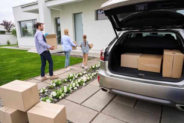istock People carry cardboard boxes with things from car to new house 1614375485
