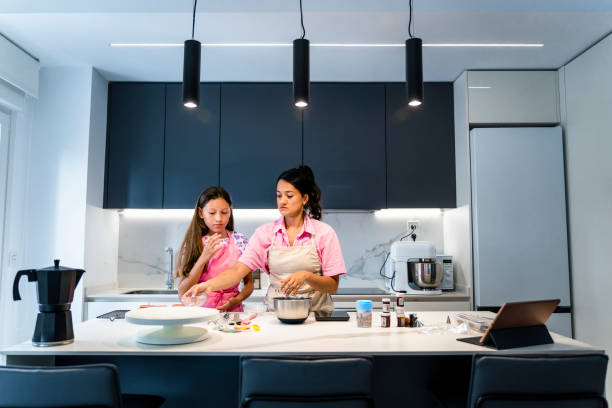 istock Mother and daughter cooking. Preparing ingredients. 1614404170