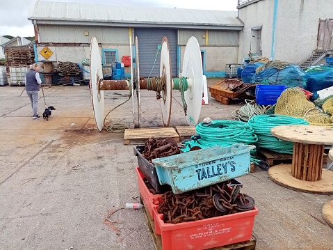 11th August 2023, Dublin, Ireland. Industrial fishing rope and net wooden spool, pallets and fish trays on Port Oriel harbour, Clogherhead, County Louth.