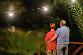Mature couple looking at the view from their patio at night