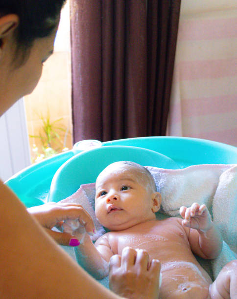 istock baby calmly looking at his mother while being bathed 1614416570