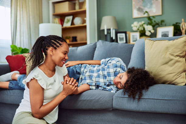 istock A smiling African woman is on the floor talking with her son while he lying on a couch. 1614430883