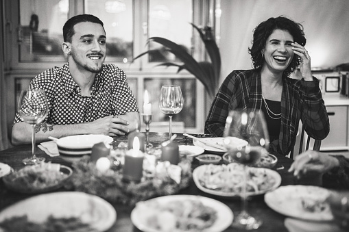 two people sitting around wooden dining table with food and advent wreath