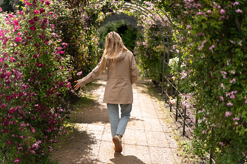 Blonde woman walks through flower gardens