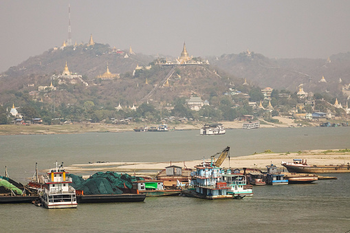 Mandalay, Myanmar - Feb 21, 2016. Cargo boats on the Irrawaddy River in Mandalay, Myanmar.