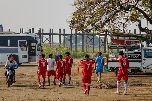 Yangon, Myanmar - Feb 21, 2016. Soccer team walking on rural road in Yangon, Myanmar. Yangon is the country largest city with a population above 7 million.