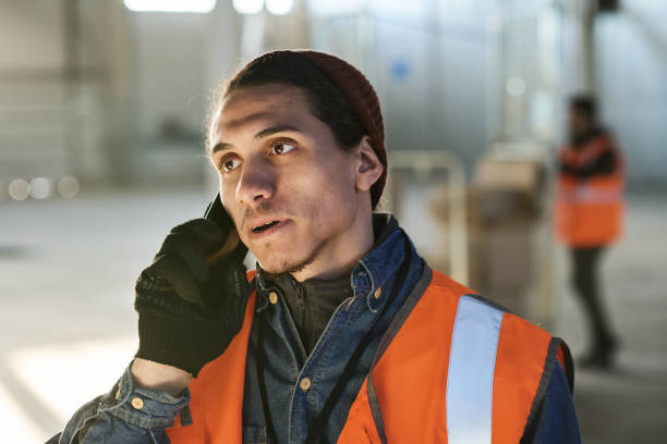 istock Young confident male engineer in workwear speaking on mobile phone 1614483982