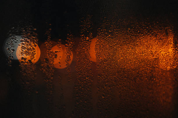 istock Wet glass after the rain with blurry lights 1614490427