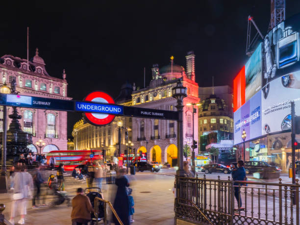 London, United Kingdom - October 8, 2014: View of London Piccadilly Circus West End district seen at night with people and Underground station in view.  This world famous district in London is well known for its tourist attractions including theaters and restaurants. 