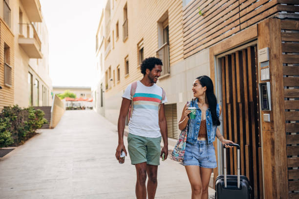 istock Two tourists leave the accommodation where they stayed drinking coffee from a disposable cup 1614494836