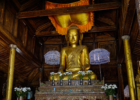 Nyaungshwe, Myanmar - Feb 14, 2016. Golden Buddha at an ancient wooden monastery in Shan State, Myanmar.