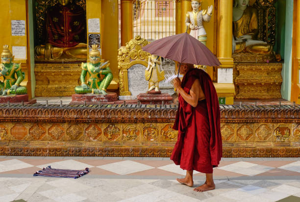 Yangon, Myanmar - Feb 26, 2016. A monk walking at Shwedagon Pagoda in Yangon, Myanmar. The Pagoda is believed by Buddhists to be around 2500 years old.