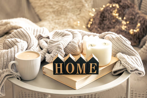 Cozy composition with candles, coffee and decorative word home.