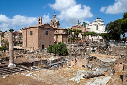 Rome, Italy - August 06, 2023: View of the imperial forums of Rome on a sunny day, people are present.