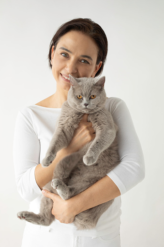 A woman is hugging her cat.