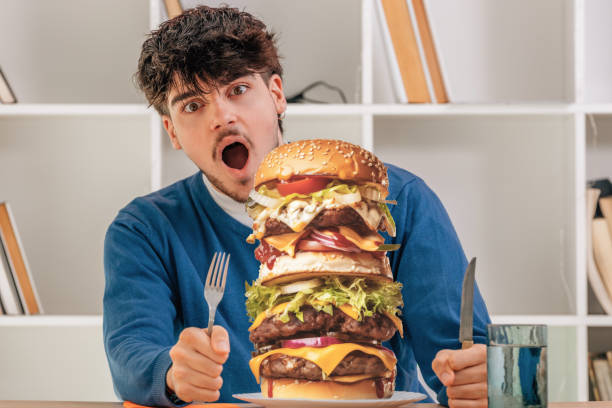 istock boy eating hamburger, fast food 1614617968