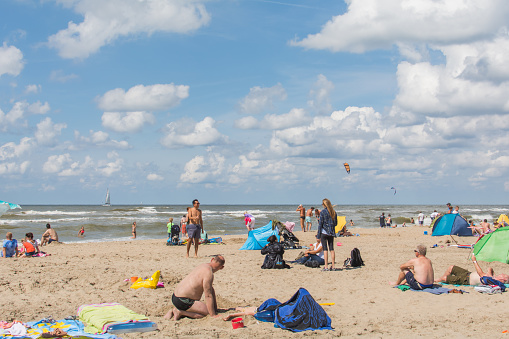 Katwijk aan Zee, Netherlands - August 6, 2017: Many people are having fun on the beach and in the sea on a beautiful summer day in Katwijk aan Zee. Take a break or celebrate a holiday.