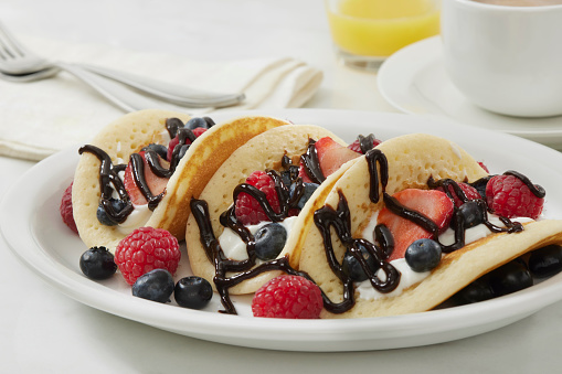 The Viral Pancake Breakfast Taco with Yogurt, Strawberry's, Raspberry's, Blueberries and Chocolate Sauce