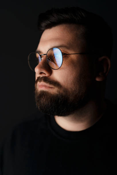 istock Bearded man in eyeglasses in the dark 1614699893