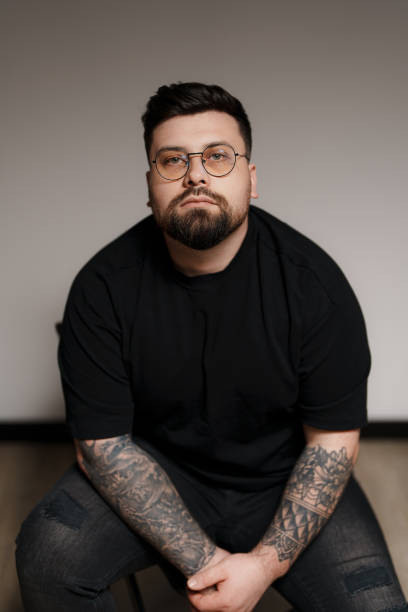 istock Bearded and tattooed man sitting on chair 1614700053