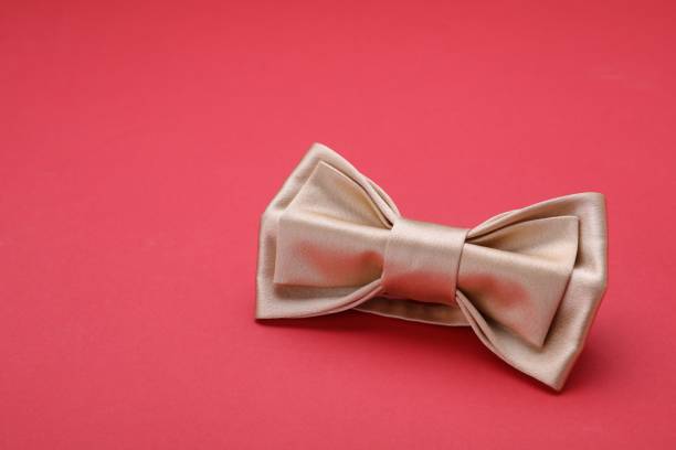 istock Stylish beige bow tie on red background, space for text 1614756311