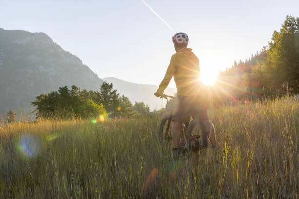 istock Mountain biker pauses in meadow at sunrise 1614757929
