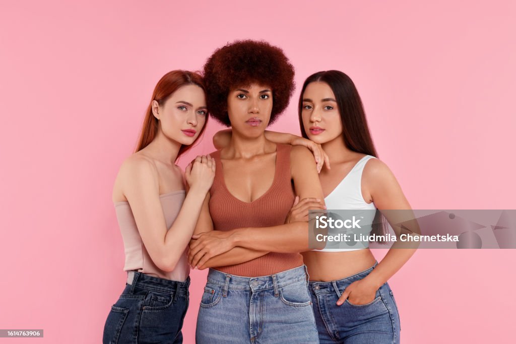Portrait of beautiful young women on pink background - Royalty-free Spijkerbroek Stockfoto Portrait of beautiful young women on pink background - Royalty-free Spijkerbroek Stockfoto