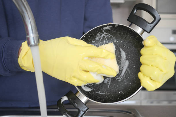 istock men washing dirty dishes in kitchen sink, closeup 1614771006
