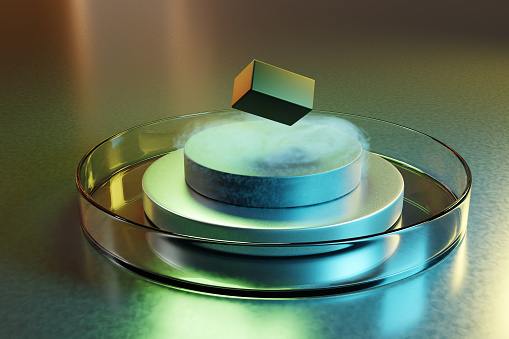 Roca flotante artificial sobre una pila de disco metálico e imán que a su vez en una placa de Petri. Ilustración del concepto de superconductores potenciales a temperatura ambiente photo