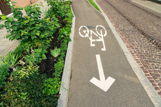 radweg-schild-logo auf asphaltstraße des europäischen straßenurbanismus-konzepts - bicycle sign symbol bicycle lane stock-fotos und bilder