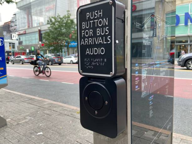 cartello "push button for bus arrivals audio" con scritta braille per ipovedenti accanto a una fermata dell'autobus mta con una mappa sulla 125th street ad harlem, new york city - commercial land vehicle audio foto e immagini stock