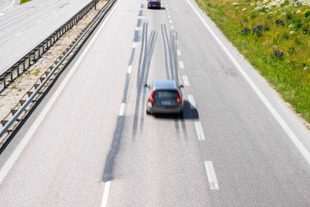 istock Car driving fast down a highway with log tire skid marks.. 1614821724